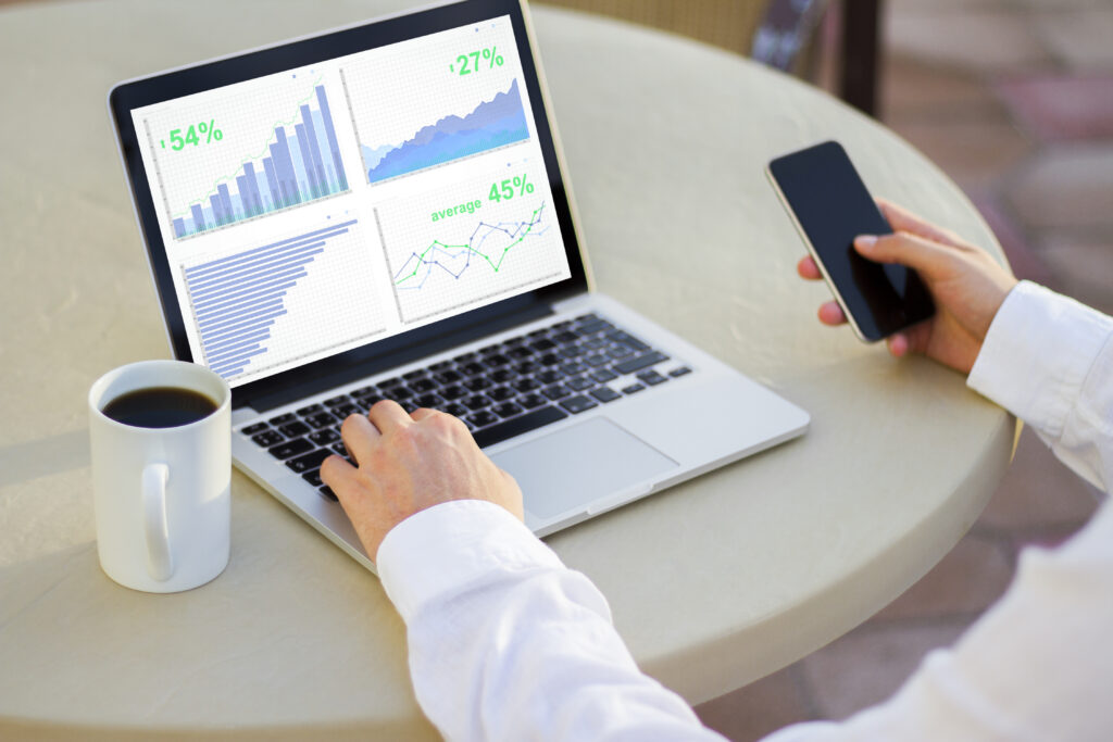 businessman looking at laptop screen with business charts