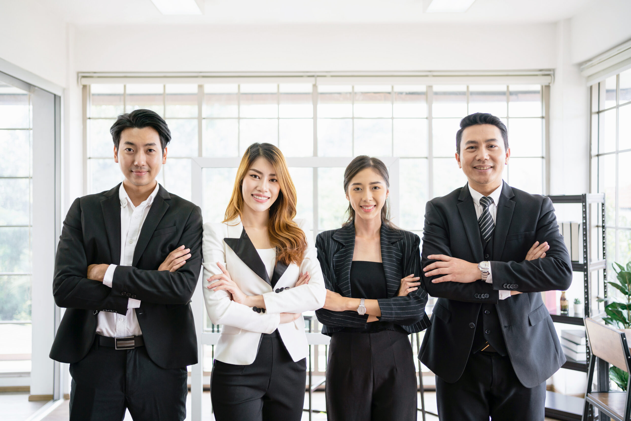 a group of confident asian businessmen and businesswomen colleagues standing in the office and looking at the camera. unity and diversity of position executive, manager and employee teamwork concept